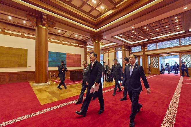 President Lee Jae Myung, center, flanked by senior aides, enters the main building of the Blue House compound in central Seoul on Dec. 29, starting his first official day of work after the relocation of the presidential office from Yongsan. [BLUE HOUSE]