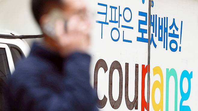 A person walks by a Coupang delivery truck in Seoul on Dec. 28. [YONHAP]