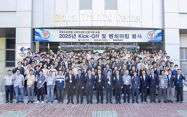 삼성전자가 지난 9월 중소기업중앙회, 중소벤처기업부와 함께 개최한 '대중소 상생형 스마트공장 선정 기업 초청 2025년 킥오프 및 벤치마킹 행사'에서 단체 사진을 찍었다. 박승희 삼성전자 사장(앞줄 오른쪽 여덟째)을 비롯한 주요 인사들이 포즈를 취하고 있다. 삼성전자