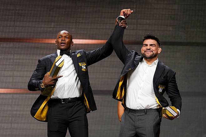 지난 6월 UFC 명예의 전당에 오른 이즈리얼 아데산야(왼쪽)와 켈빈 개스텔럼이 손을 치켜들며 기뻐하고 있다. [게티이미지]