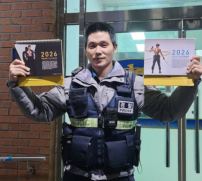 ▲ 박성용 경위가 부천원미경찰서 중앙지구대 앞에서 2026년도 남녀 탁상형 달력을 들고 있는 모습.