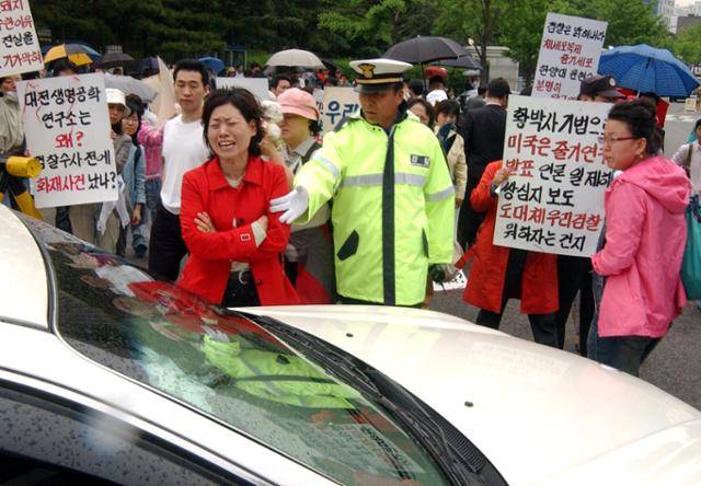 황우석 사건 최종 수사 결과가 발표된 2006년 5월 12일 서울중앙지검 앞에서 황우석 지지자들이 검찰 직원들을 향해 거세게 항의하고 있다. 한국일보 자료사진
