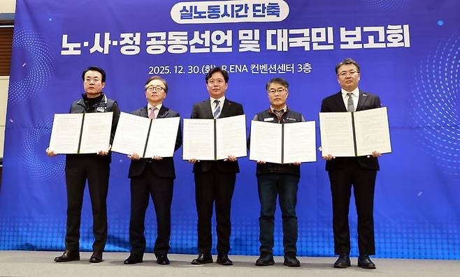 [서울=뉴시스] 김영훈 고용노동부 장관이 30일 서울 R.ENA 컨벤션센터에서 열린 대국민 보고회에서 노사정 전문가 협의체 '실노동시간 단축 로드맵 추진단' 공동 선언 및 추진 과제를 발표한 뒤 기념사진을 촬영하고 있다.왼쪽부터 강석윤 한국노총 상임부위원장, 이동근 한국경영자총협회 상근부회장, 김영훈 장관, 한성규 민주노총 부위원장, 오기웅 중소기업중앙회 상근부회장. (사진=고용노동부 제공) 2025.12.30. photo@newsis.com *재판매 및 DB 금지