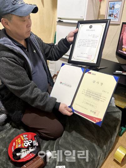 서울 종로구 돈의동 쪽방촌에 거주하는 김현수 씨가 사회복지사의 도움으로 2년째 금주하고 있다며 ‘단주기념증서’를 들어보이고 있다.(사진=석지헌 기자)