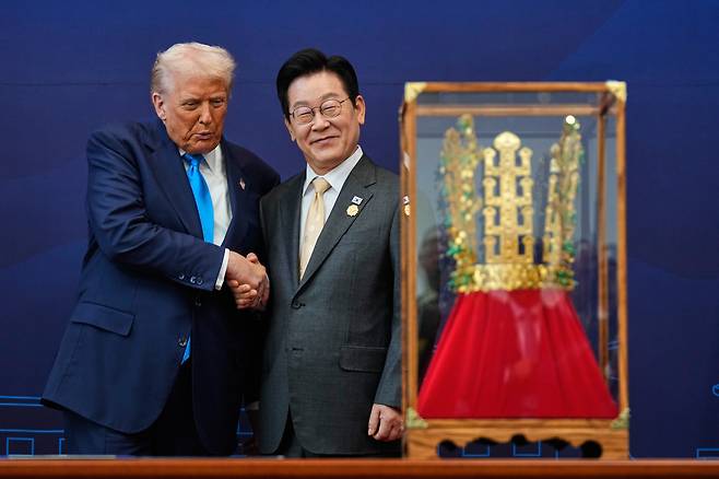 Korean President Lee Jae Myung, right, shakes hands with U.S. President Donald Trump as he gifts a gold crown and an award of the Grand Order of Mugunghwa, not seen, during a ceremony at the Gyeongju National Museum in Gyeongju, North Gyeongsang, on Oct. 29. [AP/YONHAP]