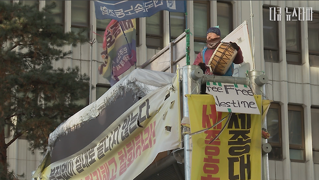 고진수 지부장이 올해 마지막 날인 12월 31일 오전 8시, 서울 명동 세종호텔 앞 철제구조물 위에서 정리해고의 부당함을 알리는 322번 째 출근 선전전을 하고 있다