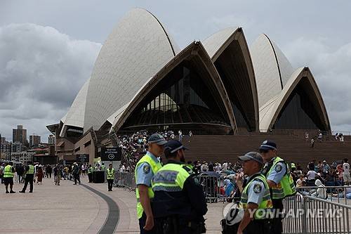 '총격테러' 시드니, 새해 불꽃놀이에 역대 최대 경찰력 투입 31일(현지시간) 호주 시드니 오페라하우스 주변에 새해 맞이 불꽃놀이를 보기 위한 인파가 모이는 가운데 경찰이 주변을 감시하고 있다. [시드니 로이터=연합뉴스 제공]