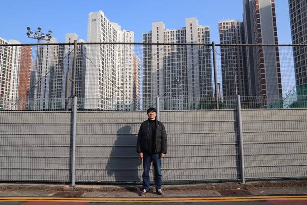 자신이 태어나 살고 있는 마산을 소재로 작업하는 설치미술가 최수환이 회원2동 재개발 지역에 들어선 아파트를 배경으로 사진을 찍고 있다. /이서후 기자