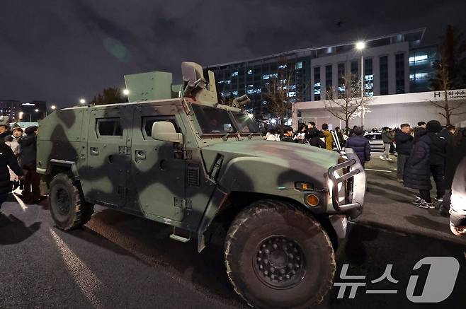 윤석열 전 대통령이 비상계엄령을 선포한 지난 2024년 12월 4일 새벽 서울 여의도 국회 앞 계엄군 차량 뒤로 군 헬기가 경내로 비행하고 있다. 2024.12.4/뉴스1 ⓒ News1 구윤성 기자