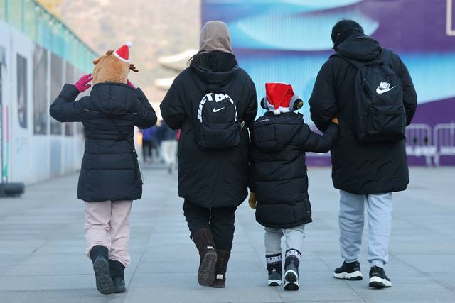 기온이 영하권으로 떨어지며 추운 날씨를 보인 지난달 25일 서울 종로구 광화문광장에서 산타 모자와 루돌프 모자를 쓴 어린이들이 엄마, 아빠와 함께 걷고 있다. [연합뉴스]