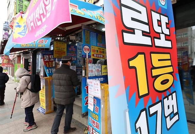 한 복권판매점 앞에 시민들이 복권 구입을 위해 줄을 서 있다./연합뉴스