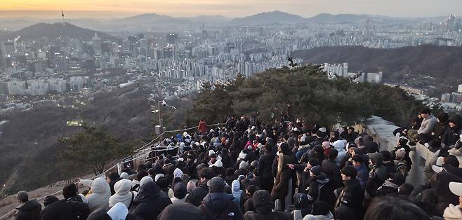Citizens wait for the sunrise atop Inwang mountain in Seoul on Thursday. (Yonhap)
