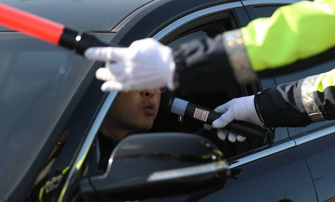 Police officers from the Jeju Provincial Police Agency and the autonomous police unit conduct an intensive drunk-driving crackdown on a road near the Georosa intersection in Geonip-dong, Jeju City, on Dec. 8. (Newsis)
