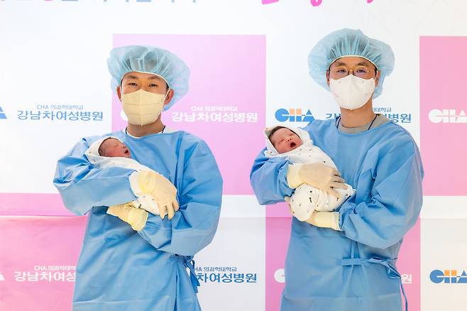 The fathers of the first babies to be born in 2026 hold their daughters, one nicknamed Jjaemi, left, and Dori on Jan. 1. The girls were born at almost the same time as the new year began.  [CHA MEDICAL CENTER GANGNAM]