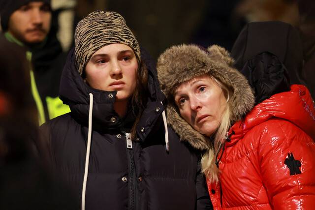 1일 화재 참사가 발생한 스위스 발레주 크랑몽타나의 ‘르 콩스텔라시옹’ 바 앞에서 시민들이 망연자실한 표정으로 서 있다. 로이터 연합뉴스