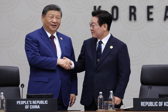이재명 대통령(오른쪽)이 지난해 11월 1일 경주화백컨벤션센터(HICO)에서 열린 2025 아시아태평양경제협력체(APEC) 정상회의 의장국 인계식에서 2026 APEC 의장국인 중국의 시진핑 국가주석에게 의장직 지위를 넘기며 악수하고 있다. 연합뉴스