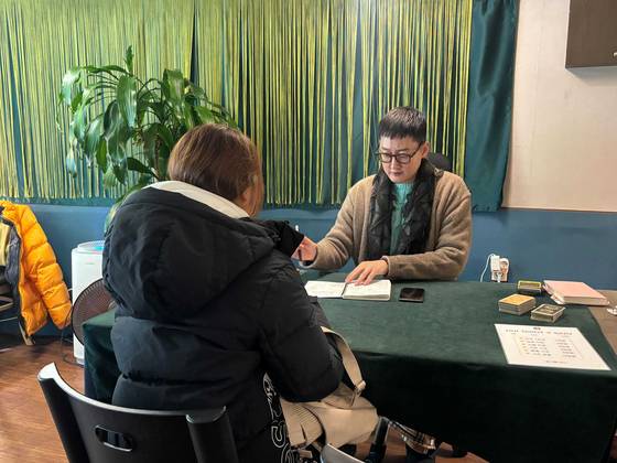 지난해 12월 31일, 강남구의 한 점집에서 시민이 타로점을 보고 있다. 류효림 기자