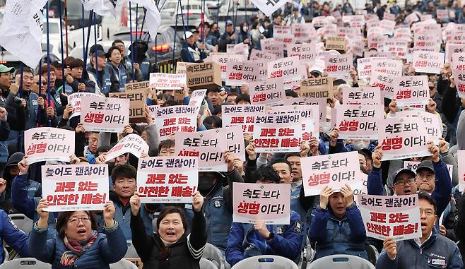 Delivery workers chant slogans ahead of a civic march titled “Creating Parcel Delivery Without Deaths From Overwork,” held in front of Dongshipjagak Pavilion at Gwanghwamun Square in Seoul on Nov. 23, 2025. The debate over early-morning delivery was sparked last month after the parcel delivery workers’ union on Oct. 22 of last year called for restrictions on “late-night delivery” between midnight and 5 a.m., citing workers’ sleep time and health rights. Coupang’s labor union and consumer groups oppose limits on early-morning delivery, arguing the right to work and consumer convenience. [NEWS1]