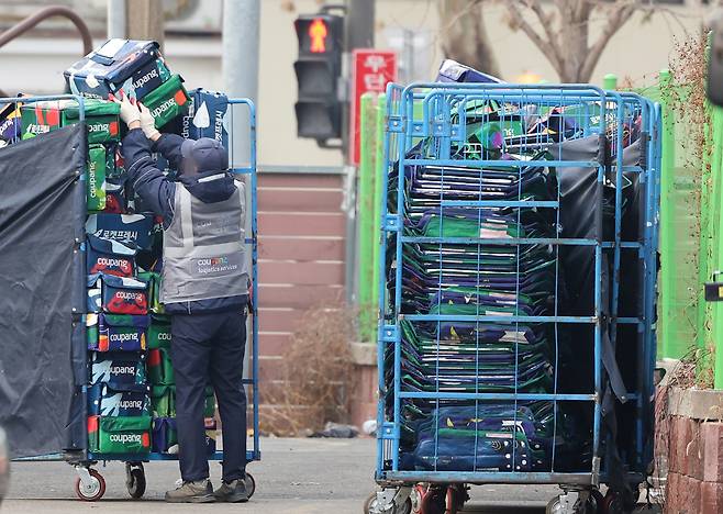 A worker organizes Rocket Fresh delivery parcels in front of Coupang's logistics center in Seoul on Dec. 28, 2025. [NEWS1]