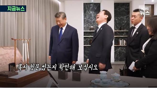 이재명 대통령과 시진핑 중국 국가주석이 선물을 교환하며 대화하고 있다. 이 대통령이 중국의 샤오미 휴대폰 선물에 '통신보안'을 언급하자, 시 주석은 "혹시 뒷문 있는지 확인해 보십시오"라고 응수했다./KBS