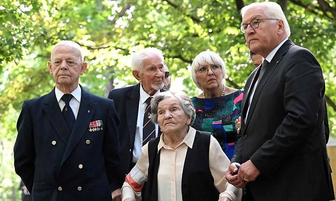 지난 2024년 바르샤바 봉기 80주년을&nbsp;앞두고 폴란드를 방문한 프랑크 발터 슈타인마이어 독일 대통령(오른쪽)이 생존자 및 그 가족들과 함께 희생자 묘역을 둘러보고 있다. 연합뉴스