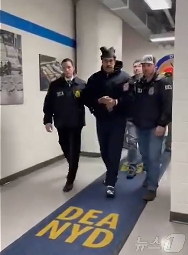 니콜라스 마두로 베네수엘라 대통령이 3일(현지시간) 미국 마약단속국(DEA) 요원에게 이끌려 '퍼프 워크'(perp walk·수사기관이 피의자를 언론 카메라에 의도적으로 노출시키는 행위)를 하는 모습이 공개됐다. (백악관 긴급대응 엑스 계정 게시물 캡쳐) 2026.1.4/뉴스1