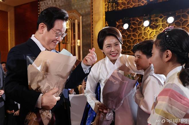 (베이징(중국)=뉴스1) 허경 기자 = 중국을 국빈 방문 중인 이재명 대통령과 김혜경 여사가 4일 베이징 한 호텔에서 열린 재중 한국인 간담회에서 화동에게 꽃다발을 받고 있다. 2026.1.4/뉴스1 Copyright (C) 뉴스1. All rights reserved. 무단 전재 및 재배포, AI학습 이용 금지. /사진=(베이징(중국)=뉴스1) 허경 기자