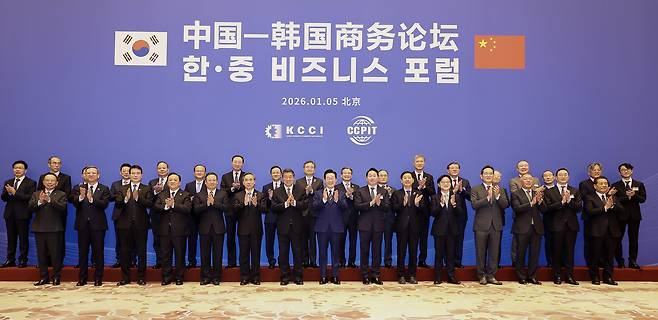 South Korean President Lee Jae Myung and Chinese Vice Premier He Lifeng join a group photo session during a forum between businesspeople of South Korea and China at the Diaoyutai State Guesthouse in Beijing on Monday. (Yonhap)