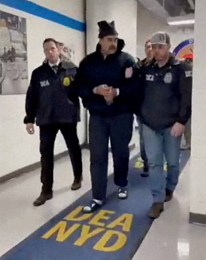 A screenshot from a video posted by the White House's Rapid Response 47 account on X, which originated from another account with the username PaulDMauro, shows Venezuelan President Nicolás Maduro being walked down a hallway at the offices of the U.S. Drug Enforcement Administration in New York City on Jan. 3. [REUTERS/YONHAP]