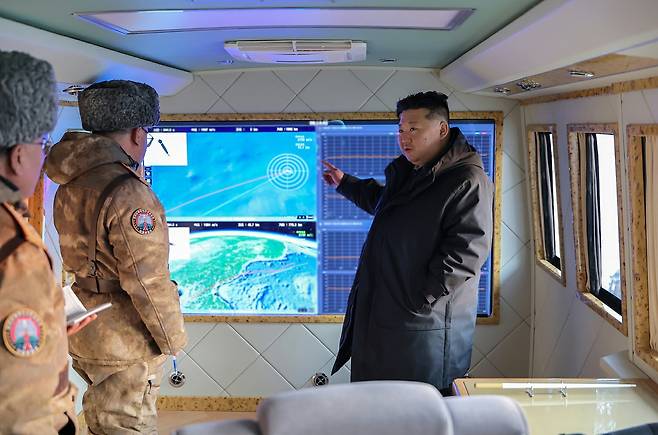Kim Jong-un, right, general secretary of the Workers’ Party of Korea, pointing at a screen of what appears to be missile logistics with officers in a photo released by the state-run Rodong Sinmun on Jan. 5. [RODONG SINMUN]