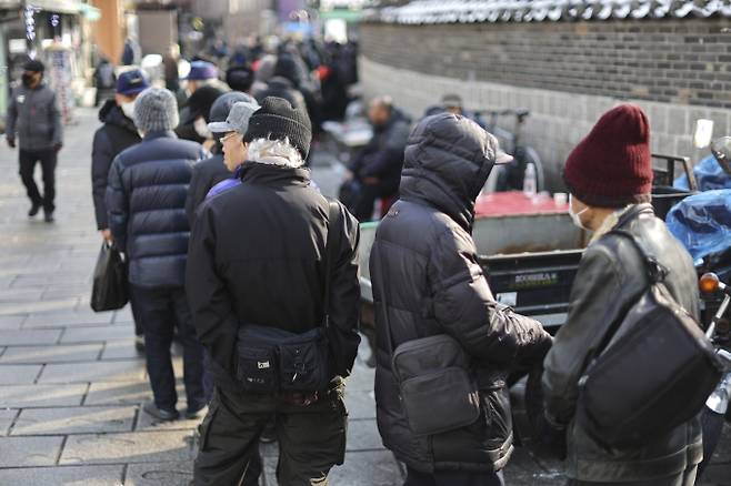 서울 종로구 탑골공원 원각사 노인 무료급식소 인근 식당가에서 노인들이 점심식사를 위해 줄을 서 있다. 연합뉴스