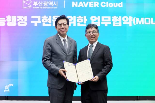 박형준(왼쪽부터) 부산광역시 시장과 김유원 네이버클라우드 대표가 지난해 4월 8일 부산시 연제구 부산시청에서 열린 ‘부산형 지능행정 구현’을 위한 업무협약식에서 체결 문서를 함께 들어보이고 있다. 네이버클라우드