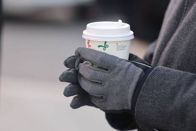 서울 종로구 광화문네거리에서 한 시민이 따뜻한 커피를 손에 들고 있다. 연합뉴스