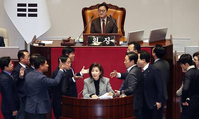 나경원 국민의힘 의원(가운데)이 2025년 12월9일 국회 본회의장에서 무제한 토론을 하는 가운데 여야 의원들이 발언대에서 목소리를 높이며 신경전을 이어가고 있다. 한겨레 김경호 선임기자