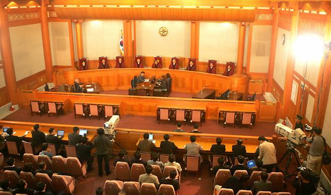 2004년 10월21일 헌법재판소는 ‘신행정수도건설특별법’에 대해 8 대 1 의견으로 위헌이라고 결정했다(왼쪽 사진). 1849년 간행된 동국여지도 중 경기 부분. ‘경(京)’이라는 글자가 성곽으로 둘러싸인 모습을 형상화해 19세기 중반 수도 한양이 확실한 위상을 지녔음을 보여준다. 개성은 다른 지역과 별 차이 없이 표현돼 있다.  경향DB·서울대학교 규장각한국학연구원 소장