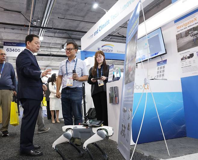 1월 6일(현지 기준), CES 2026에서 윤석대 한국수자원공사 사장(사진 왼쪽)이 K-water관 홍보 부스에 전시된 AI 기반 자율주행 로봇을 살펴보고 있다. (사진= 한국수자원공사)