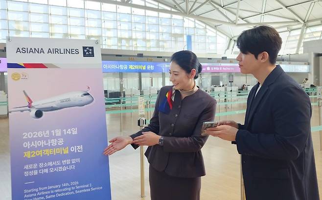 아시아나항공이 오는 14일부터 인천공항 제2여객터미널(T2)로 이전한다. 사진은 아시아나항공 직원이 승객에게 T2 이전을 안내하는 모습(아시아나항공 제공). 2026.01.07.