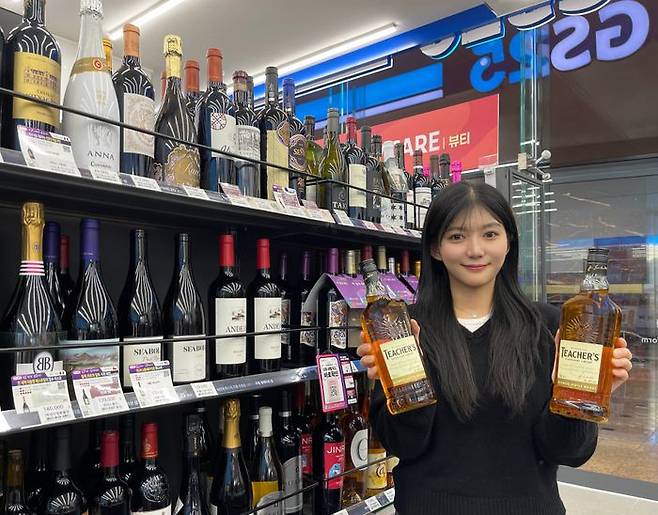 모델이 GS25에서 선보인 1만원대 가성비 위스키 '티처스' 상품을 들고 있다.ⓒGS25