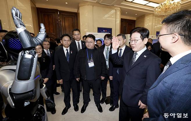 이재명 대통령이 7일 중국 상하이 국제회의중심에서 열린 한중 벤처 스타트업 서밋 행사에서 중국 기업 아지봇의 휴머노이드 로봇과 악수를 하고 있다. 상하이=송은석 기자 silverstone@donga.com