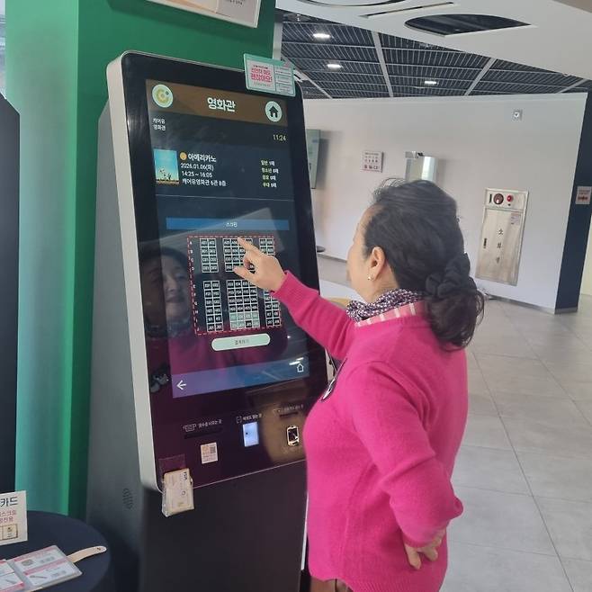 서울디지털동행플라자 매니저가 키오스크를 활용해 영화관 표와 자리 예약 시연을 하고 있다.