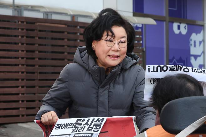 Budget minister nominee Lee Hye-hoon meets a member of Solidarity Against Disability Discrimination on her commute to work in Seoul Monday. (Yonhap)