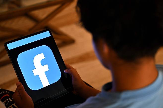 A 13-year-old boy poses at his home as he looks at social media on his tablet in Sydney on December 8, 2025. [AFP/YONHAP]