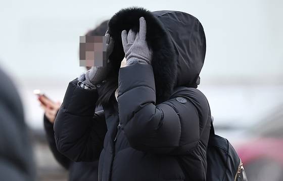 A pedestrian walks across the Gwanghwamun Square in central Seoul with a thick coat and gloves on Jan. 5. [NEWS1]