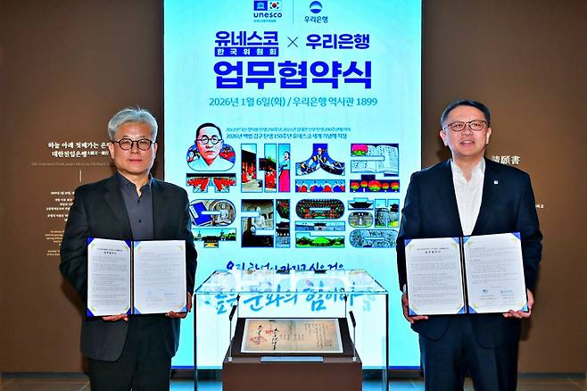 지난 6일 우리은행 역사관 '우리1899'에서 열린 협약식에서 우리은행 정진완 은행장과 유네스코한국위원회 윤병순 사무총장 직무대행이 대한천일은행 창립청원서 앞에서 기념촬영을 하고 있다. /사진제공=우리은행