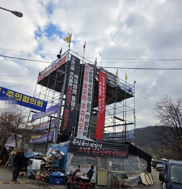 서울 강남구 구룡마을에 설치된 철제 구조물에 서울시 도시개발사업에 반대하는 현수막이 걸려 있다.  [구룡마을총통합추진주민자치위원회 제공]