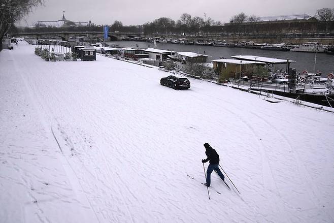 [파리=AP/뉴시스] 눈이 내린 7일(현지 시간) 프랑스 파리 센 강 인근에서 한 남성이 스키를 타고 있다. 2026.01.08.