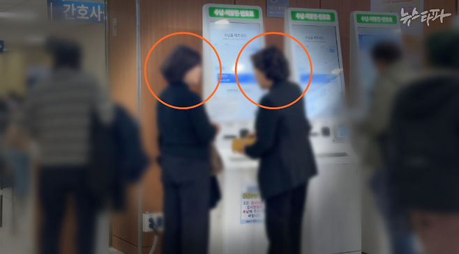 지난달 23일 서울 동작구 보라매병원에서 진료를 마친 더불어민주당 김병기 의원의 배우자 이 모 씨(오른쪽 동그라미)가 키오스크에서 병원비를 수납하는 모습. 김병기 의원실 소속 8급 비서관 김 모 씨(왼쪽 동그라미)가 이 씨를 돕고 있다.&nbsp;