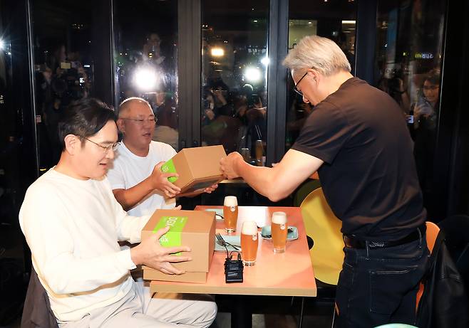 젠슨 황 엔비디아 최고경영자(CEO)가 30일 오후 서울 강남구 삼성역 인근 깐부치킨 매장에서 진행된 회동에서 이재용 삼성그룹 회장, 정의선 현대차그룹 회장에게 선물을 전달하고 있다. [연합]