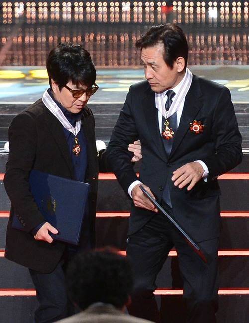 [서울=뉴시스] 중학교 동창인 가왕 조용필과 국민배우 안성기가 2013년 11월18일 서울 송파구 방이동 올림픽공원 올림픽홀에서 열린 '2013 대한민국 대중문화예술상' 시상식에서 함께 은관 문화훈장을 받은 뒤 이야기를 나누며 자리로 돌아가고 있다. (사진 = 뉴시스 DB) 2026.01.05. photo@newsis. *재판매 및 DB 금지