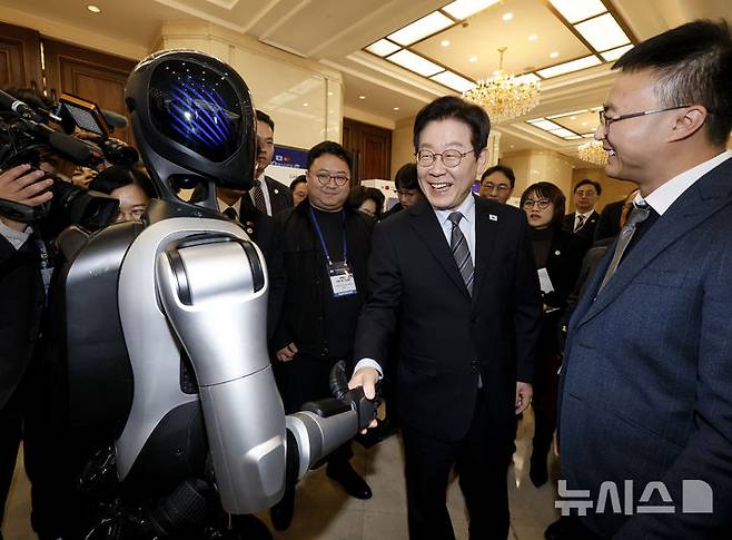 [상하이=뉴시스] 최동준 기자 = 사진은 이재명 대통령이 지난 7일(현지 시간) 상하이 상해국제회의중심에서 열린 한-중 벤처스타트업 서밋을 방문해 중국 기업 엣지봇의 휴머노이드 로봇과 악수를 하고 있는 모습. 2026.01.07. photocdj@newsis.com